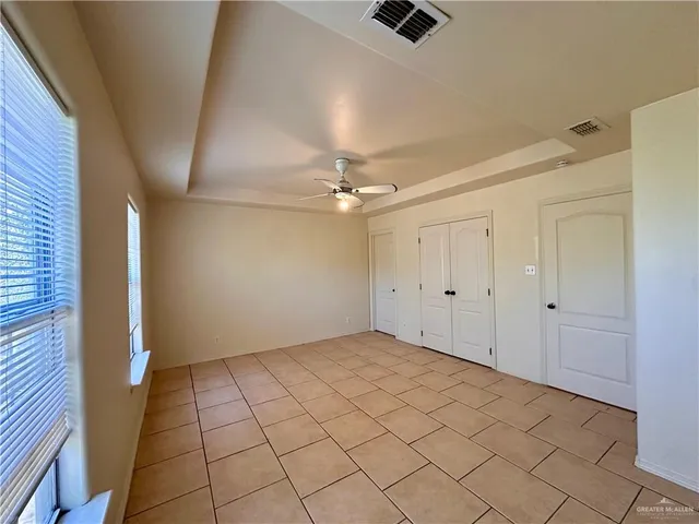 an empty room with fan and windows