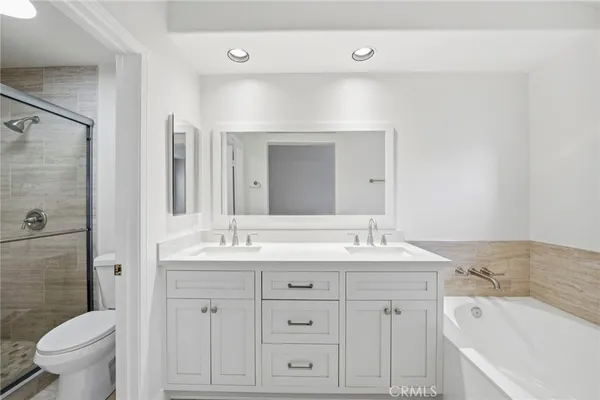 a bathroom with a bathtub sink mirror and toilet