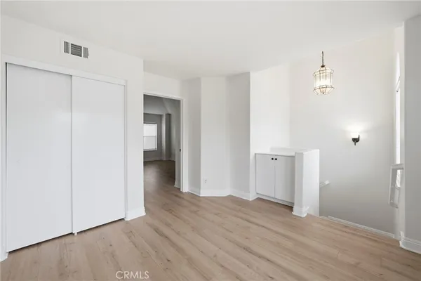 an empty room with wooden floor and closet