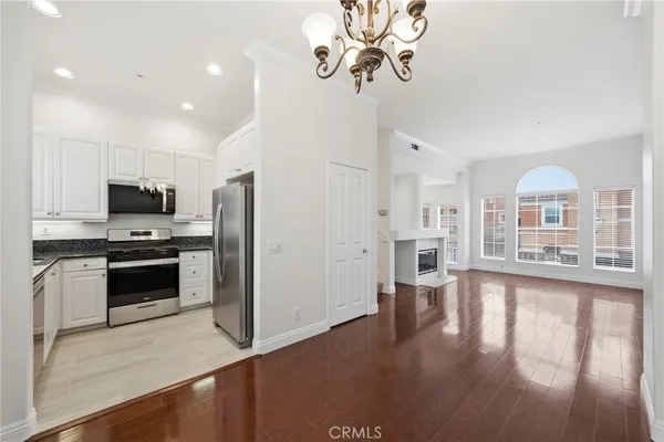 a kitchen with stainless steel appliances granite countertop a refrigerator a stove cabinets and wooden floor