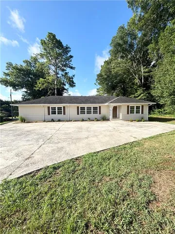 a view of house with yard and sitting area