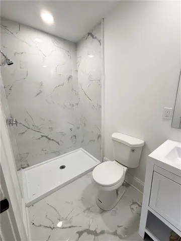 a white toilet sitting next to a bath tub and shower