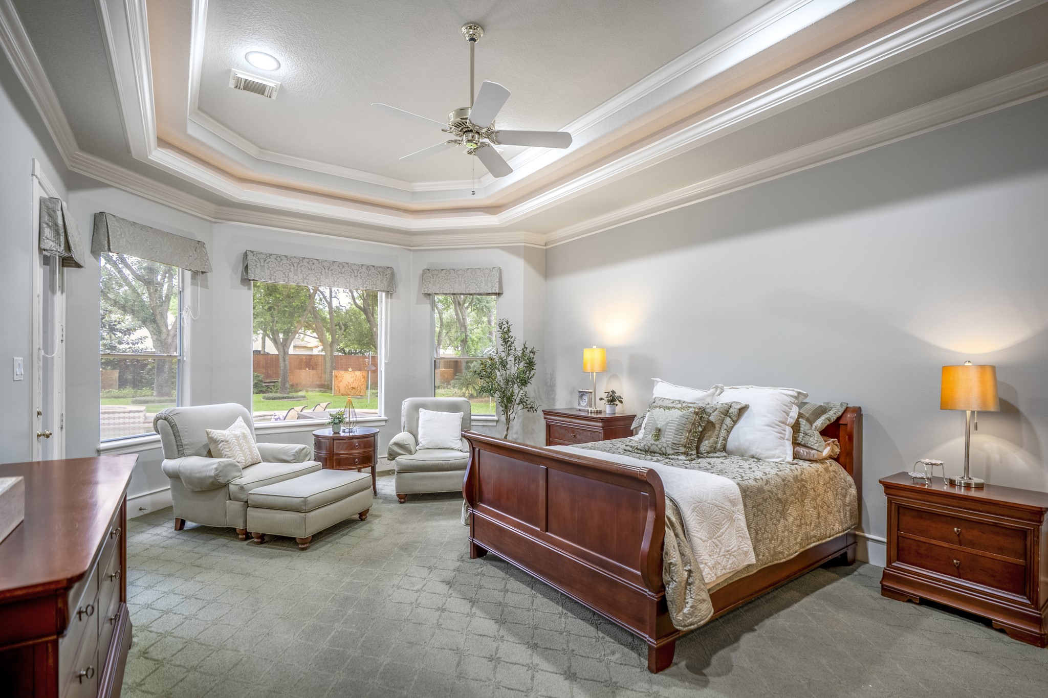 8806 Sterling Gate Circle Spring, TX 77379 - Photo 21 of 40 The primary bedroom is stunning with double stepped ceiling and cove lighting and a cozy sitting area with windows looking out to the back yard.