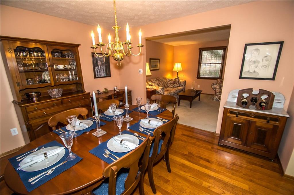 The dining room has hardwood flooring and opens to the living room.