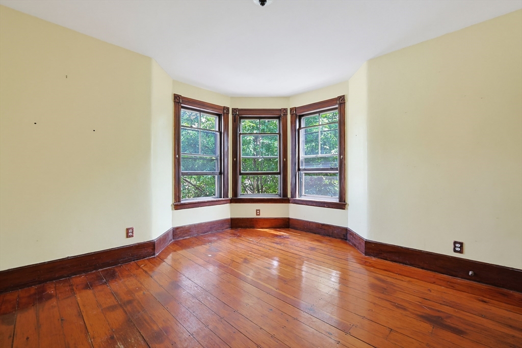7 Baker Street Worcester, MA 01603 - Photo 27 of 42 a view of an empty room with wooden floor and a window