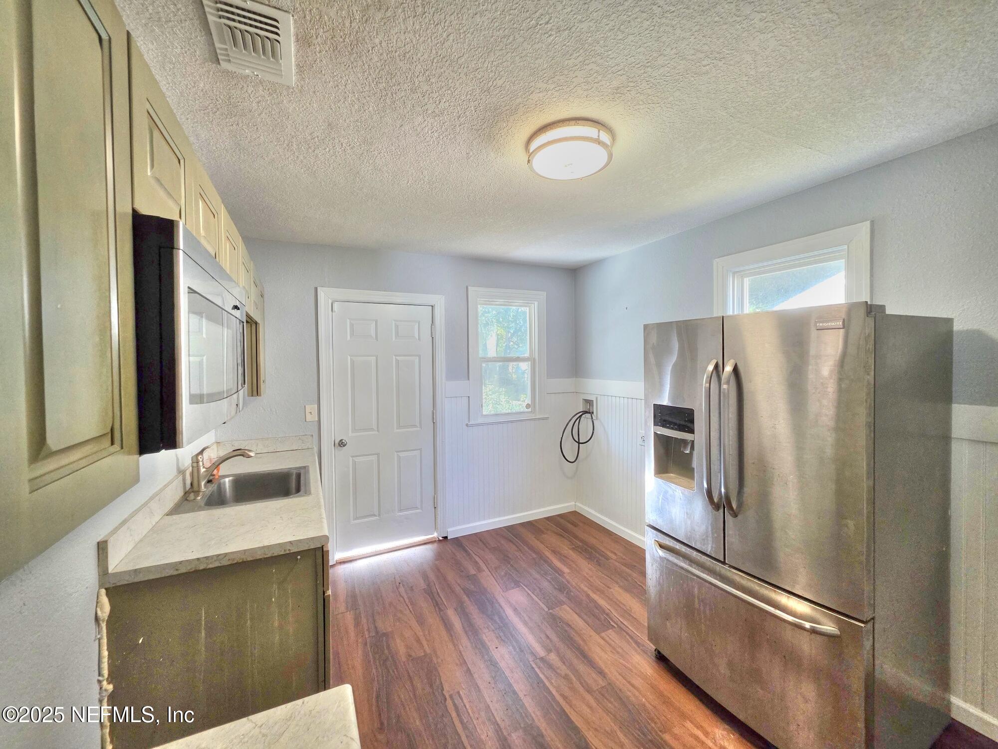616 Woodbine Street Jacksonville, FL 32206 - Photo 12 of 25 a kitchen with granite countertop a refrigerator and a sink
