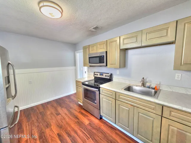 a kitchen with a sink cabinets and appliances
