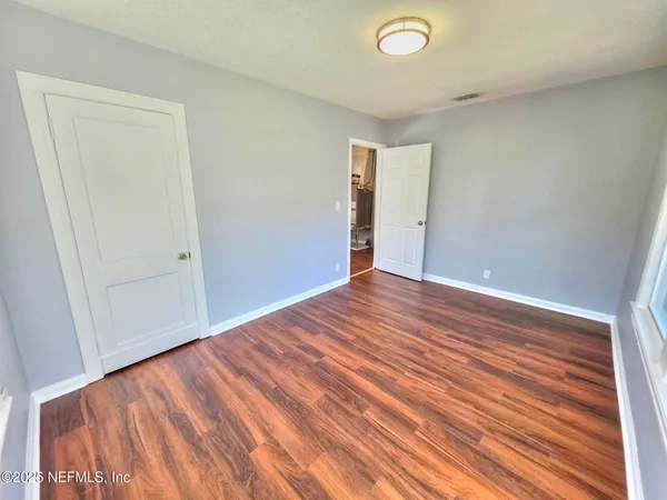 a view of empty room with wooden floor