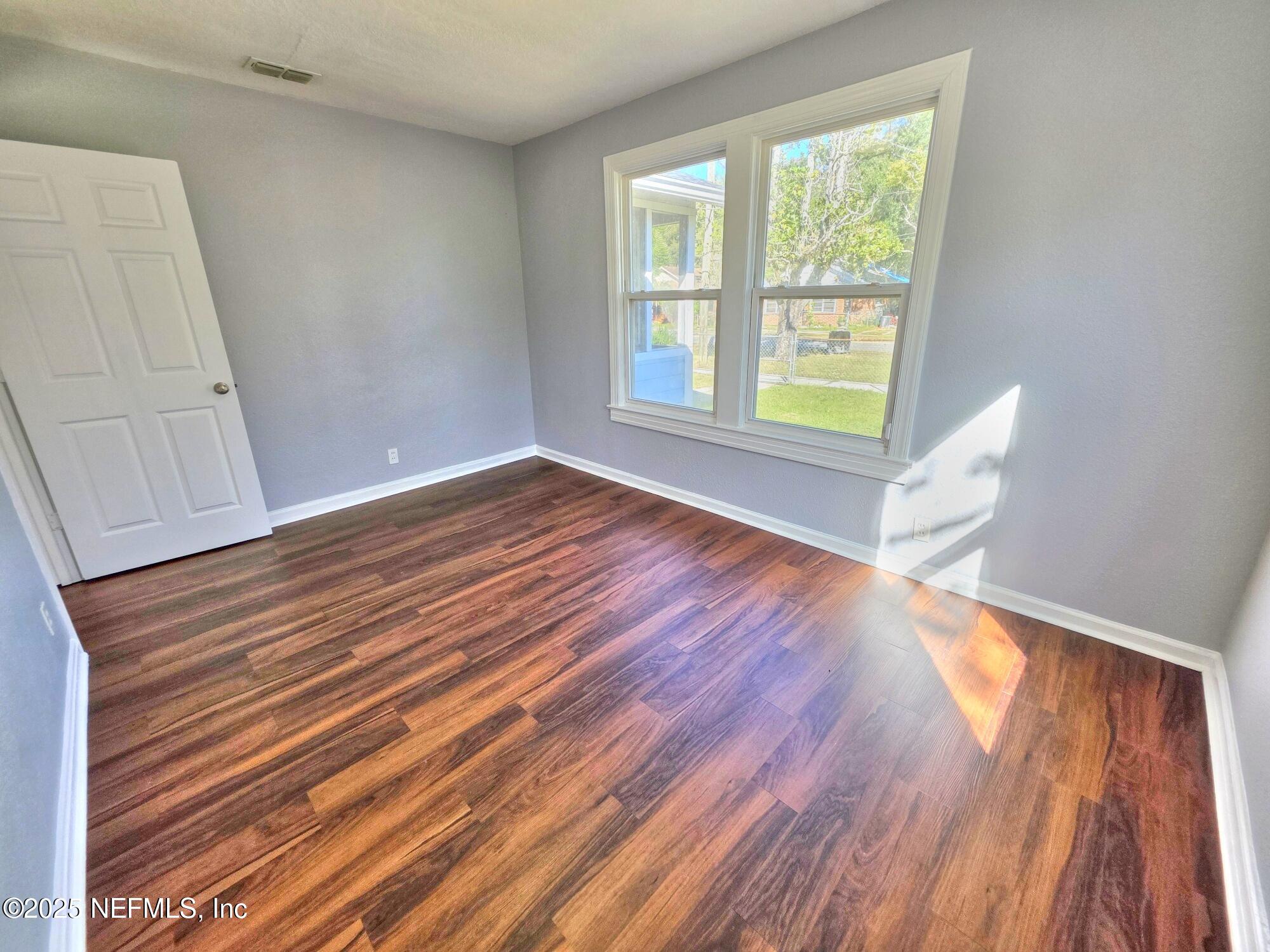 616 Woodbine Street Jacksonville, FL 32206 - Photo 23 of 25 a view of an empty room with wooden floor and a window