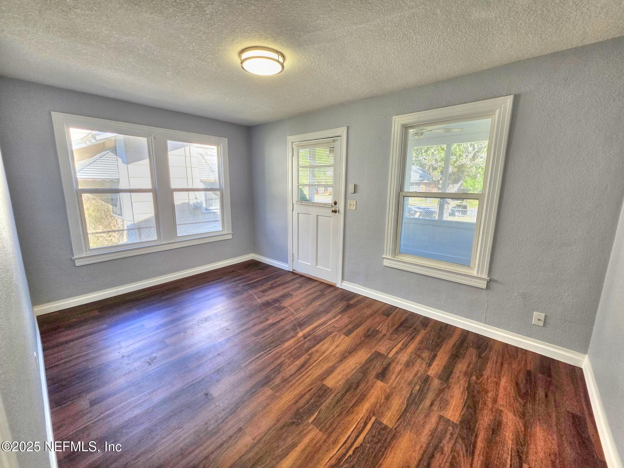 616 Woodbine Street Jacksonville, FL 32206 - Photo 9 of 25 a view of an empty room with wooden floor and a window