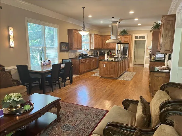 a living room with furniture kitchen view and a large window