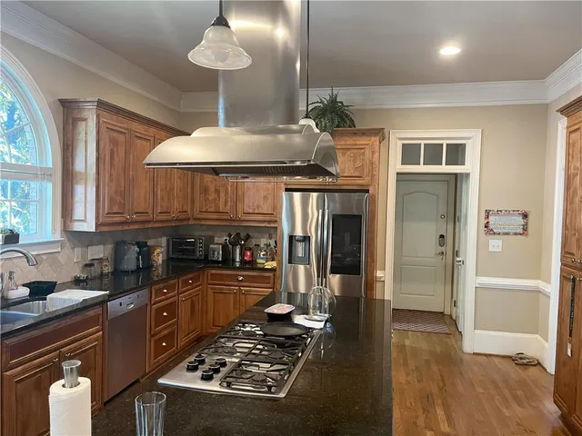 a kitchen with kitchen island granite countertop a sink cabinets and stove