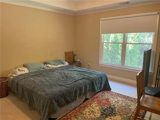 a bed sitting in a bedroom next to a window