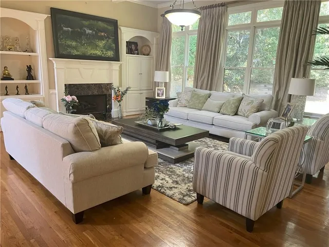 a living room with fireplace furniture and a large window