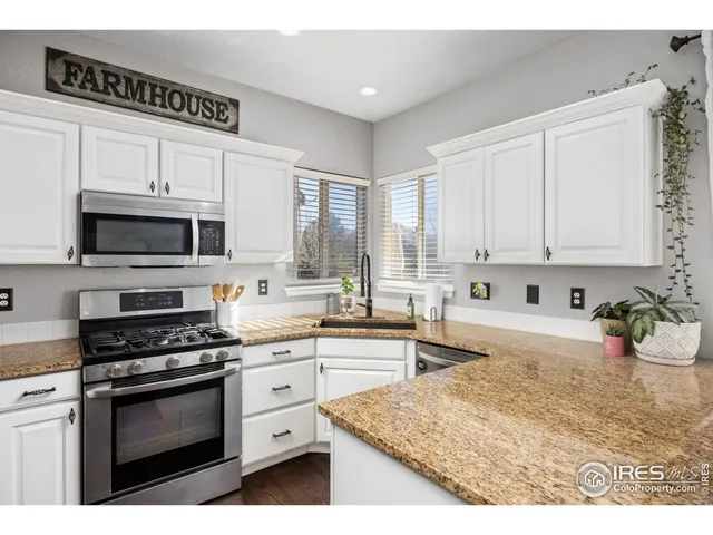 a kitchen with stainless steel appliances white cabinets a sink and a stove