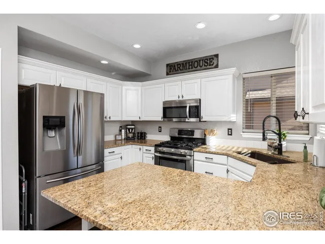 a kitchen with stainless steel appliances granite countertop a refrigerator sink and stove