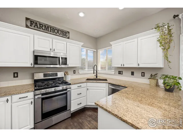 a kitchen with granite countertop a stove top oven sink and cabinets