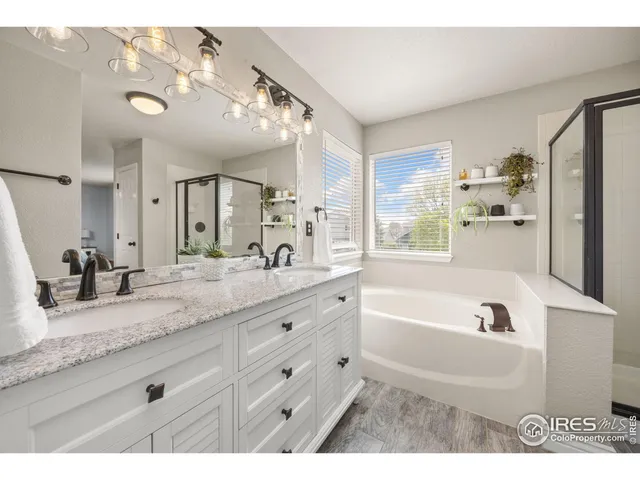 a bathroom with a granite countertop sink mirror bathtub and double