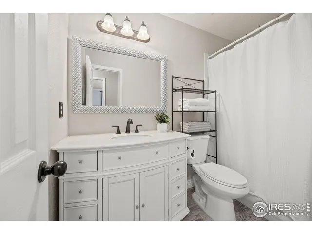 a bathroom with a sink vanity mirror and toilet