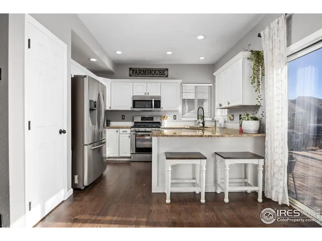a kitchen with kitchen island granite countertop stainless steel appliances refrigerator sink and cabinets