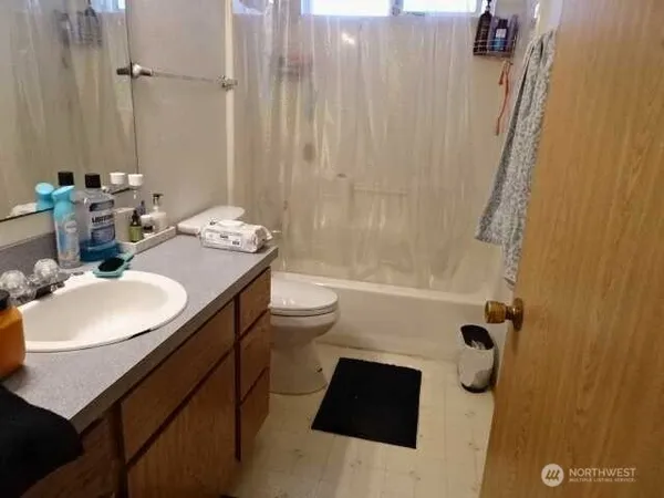 a bathroom with a sink a toilet and shower curtain
