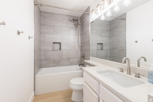11906 Woodridge Road Sandy, UT 84094 - Photo 16 of 35 Remodeled 2nd floor bathroom featuring a tub and shower combination with light gray rectangular tile surround, a built-in shower niche, and brushed nickel fixtures