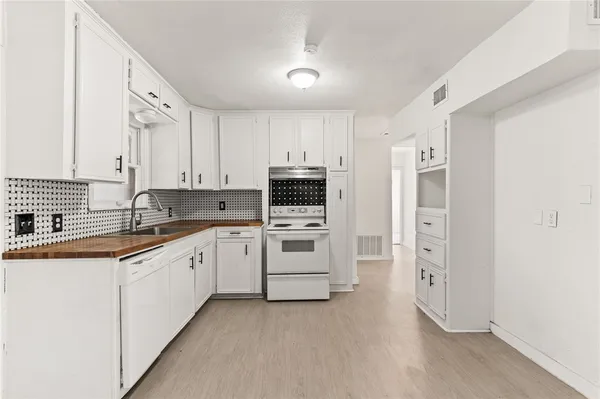a kitchen with granite countertop white cabinets and white appliances