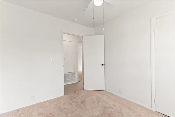 an empty room with a ceiling fan and a window