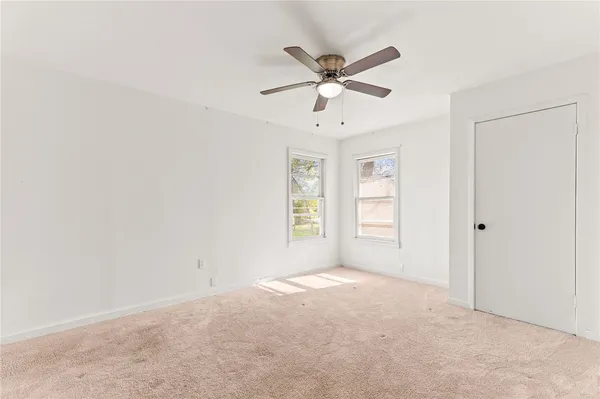 a view of a big room with windows and chandelier fan