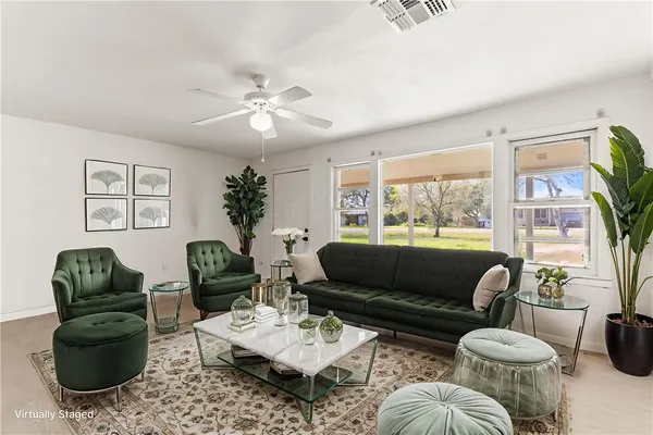 a living room with furniture a chandelier and a large window