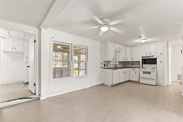 a large white kitchen with white cabinets and stainless steel appliances