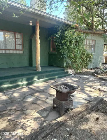 a view of a backyard with table and chairs in front of house