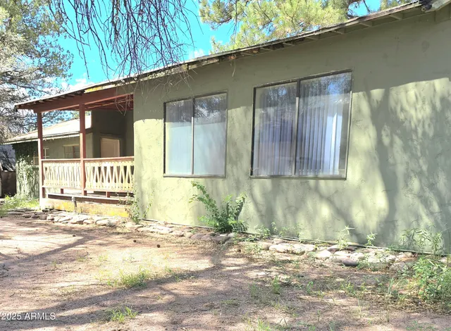 a view of backyard with wooden fence and large windows
