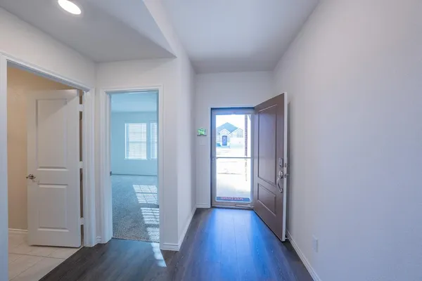 a view of a hallway with wooden floor