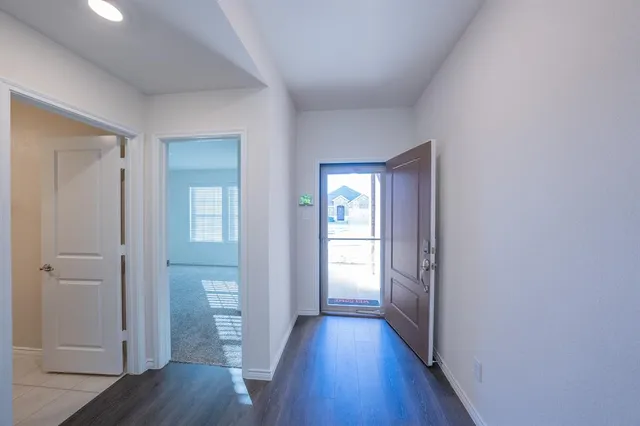 a view of a hallway with wooden floor