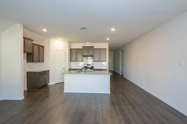 a kitchen with a sink cabinets and wooden floor