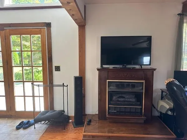 a living room with a flat screen tv a fireplace and a window