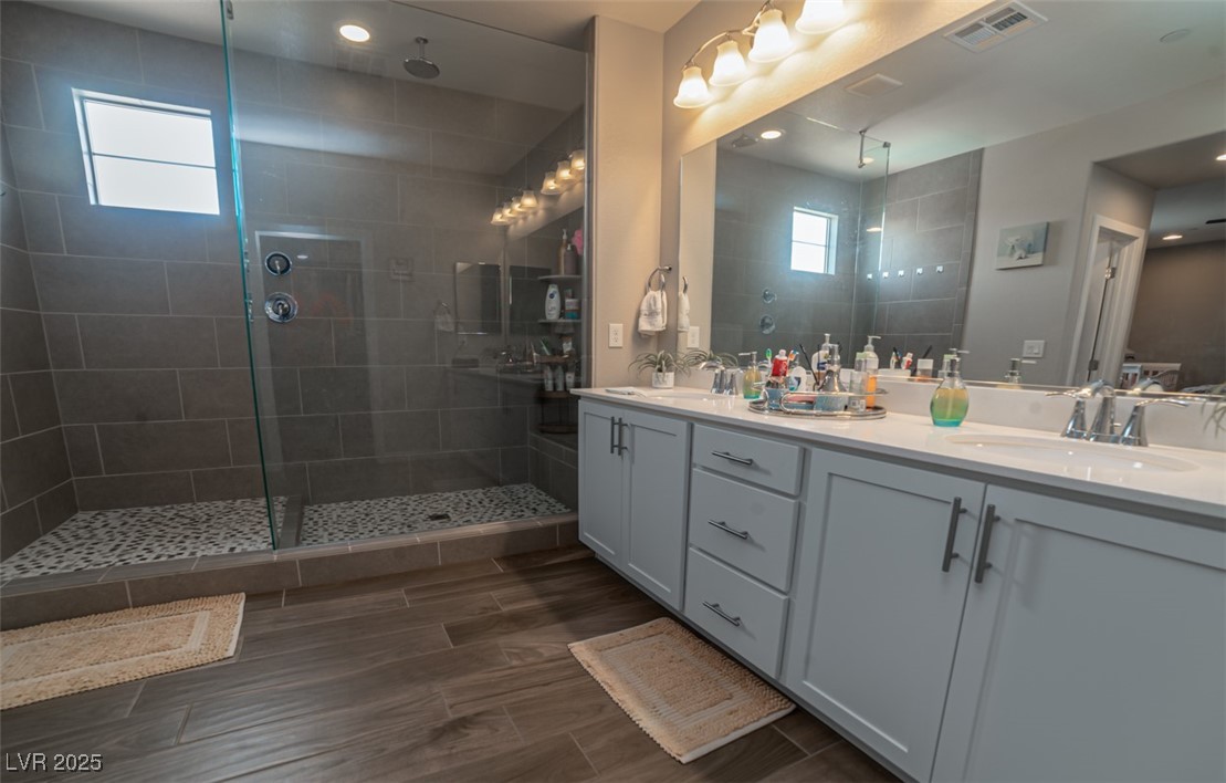 111 Verde Rosa Drive Henderson, NV 89011 - Photo 20 of 51 Full bathroom with double vanity, walk in shower, recessed lighting, and wood tiled floors
