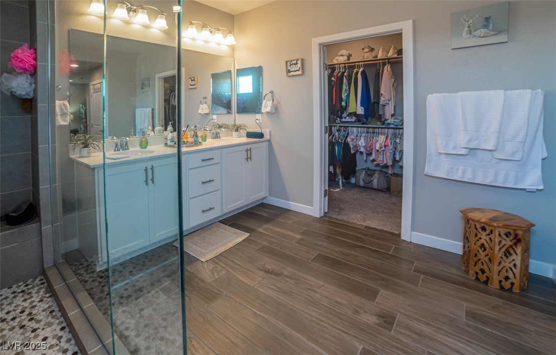 111 Verde Rosa Drive Henderson, NV 89011 - Photo 23 of 51 Bathroom with double vanity, wood tiled floors, a walk in closet, and tiled shower