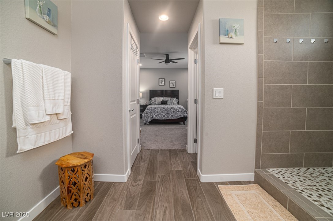 111 Verde Rosa Drive Henderson, NV 89011 - Photo 26 of 51 Bathroom featuring ensuite bathroom, dark wood-type flooring, a tile shower, ceiling fan, and a textured wall