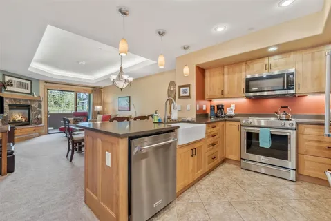 a kitchen with stainless steel appliances granite countertop a kitchen island a stove a sink a window and dining table