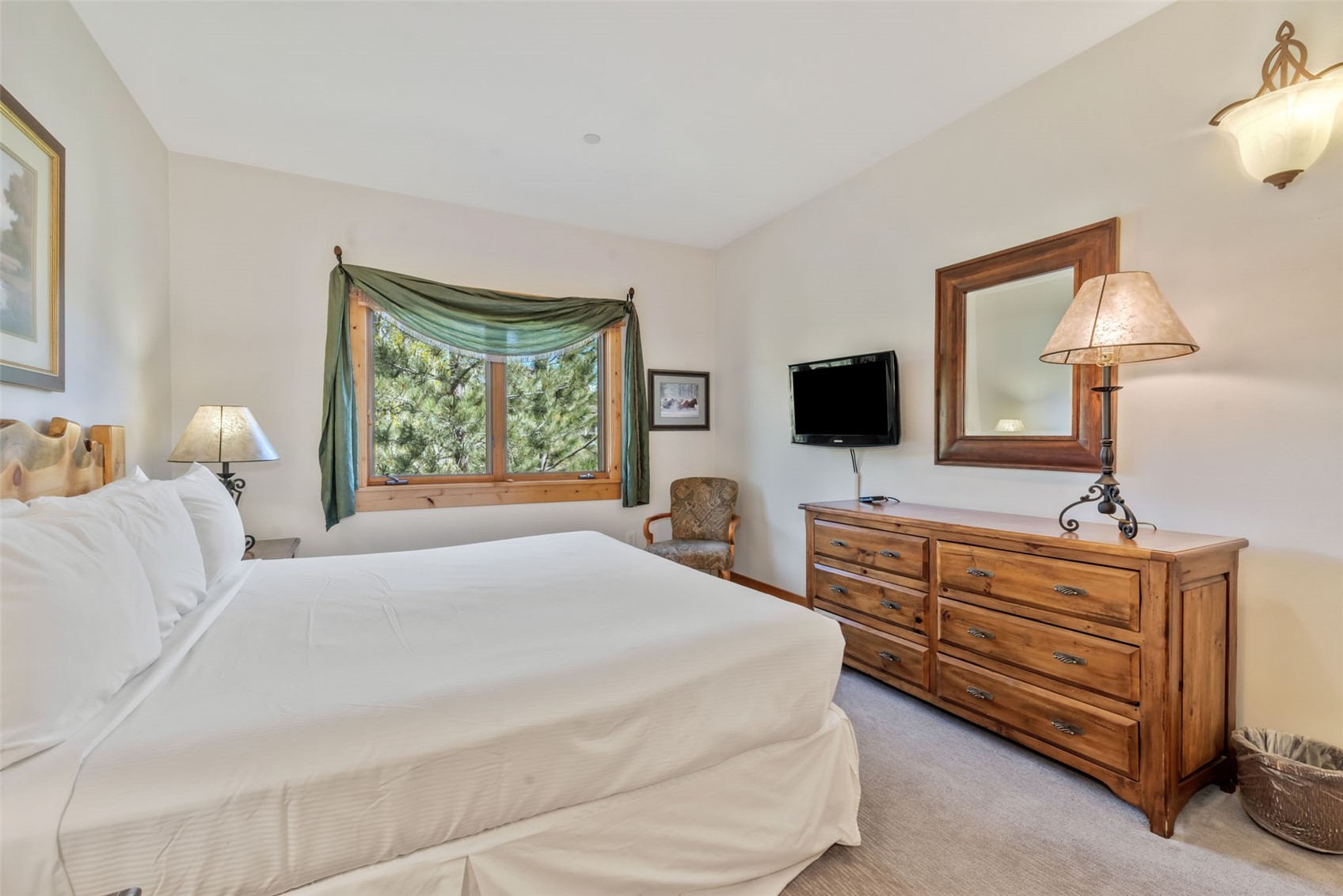 2720 Eagle Ridge Drive, Unit 207 Steamboat Springs, CO 80487 - Photo 17 of 37 a bedroom with a bed and flat tv screen on the dresser