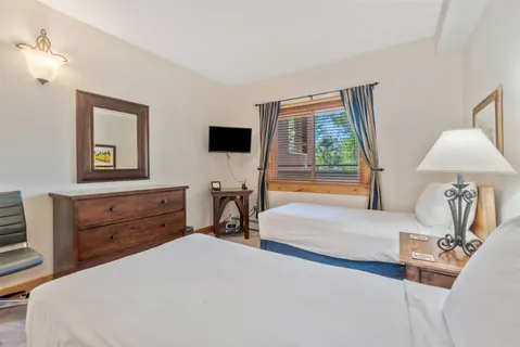 a bedroom with two beds and a painting on the wall