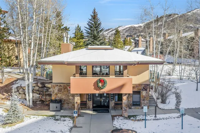 a view of a house with a yard and potted plants