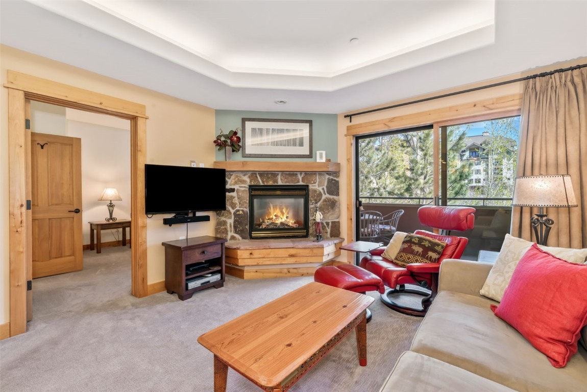 2720 Eagle Ridge Drive, Unit 207 Steamboat Springs, CO 80487 - Photo 3 of 37 a living room with furniture a flat screen tv and a fireplace