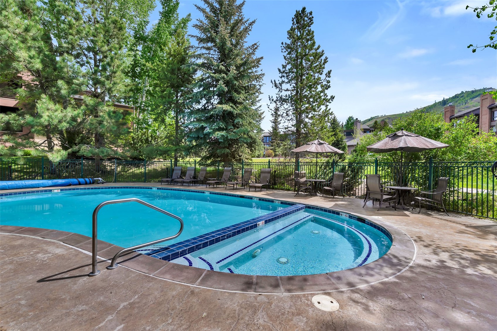 2720 Eagle Ridge Drive, Unit 207 Steamboat Springs, CO 80487 - Photo 36 of 37 a view of a swimming pool with lawn chairs under an umbrella
