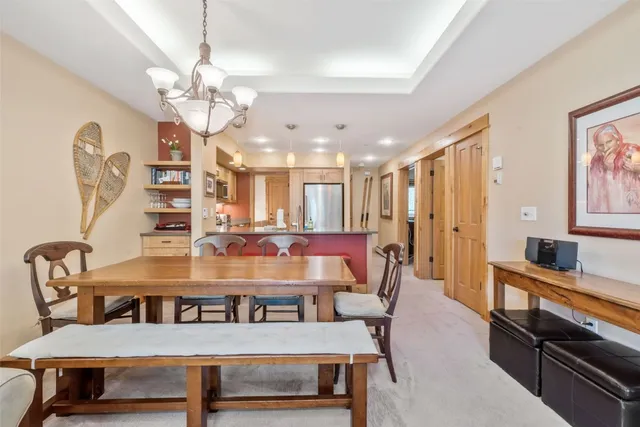 a view of a dining room with furniture a chandelier and wooden floor