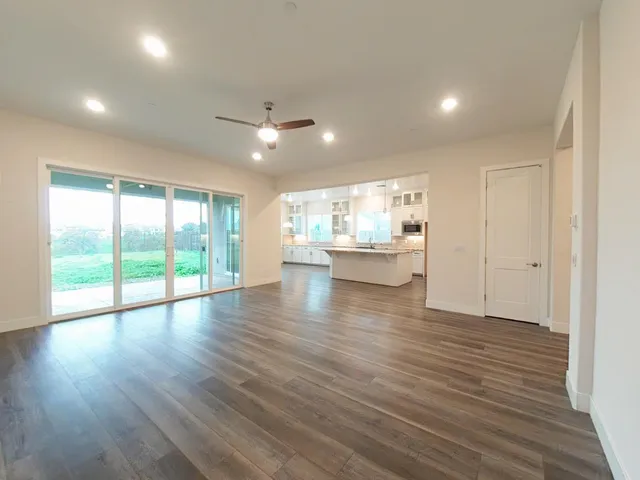 a large kitchen with granite countertop a large window and white appliances