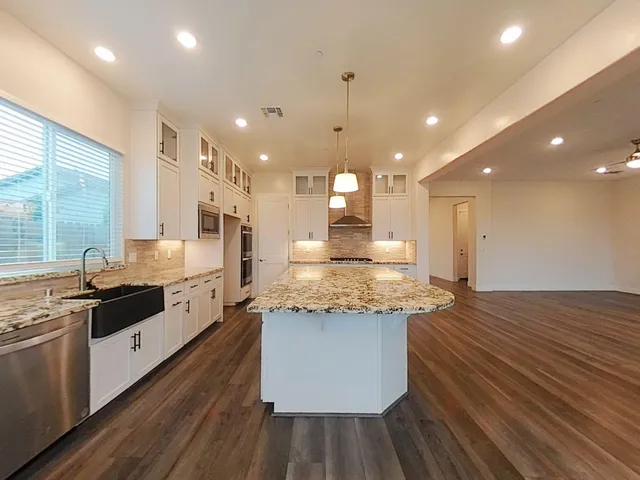 a large kitchen with stainless steel appliances kitchen island granite countertop a large counter top a sink stainless steel appliances and cabinets