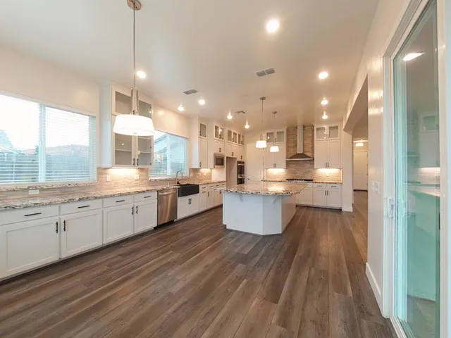 a bathroom with a granite countertop sink and a bathtub